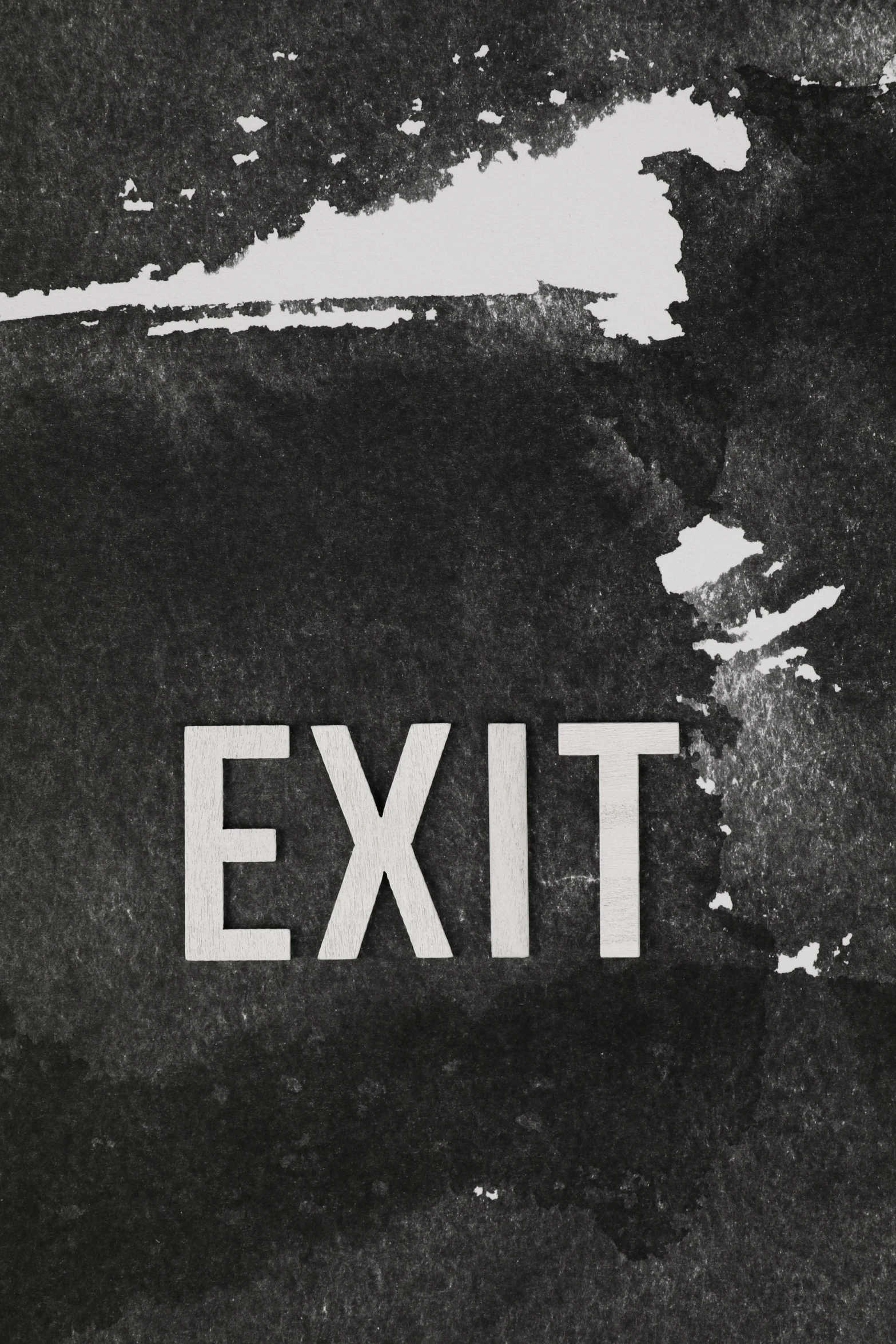 a black and white picture of a wall with the word exit written on it