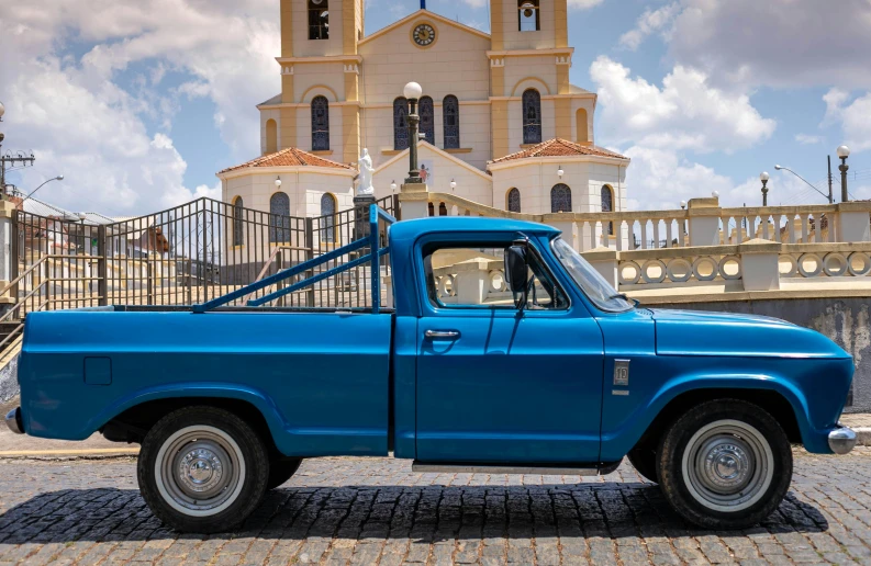 there is a blue truck parked in front of a church