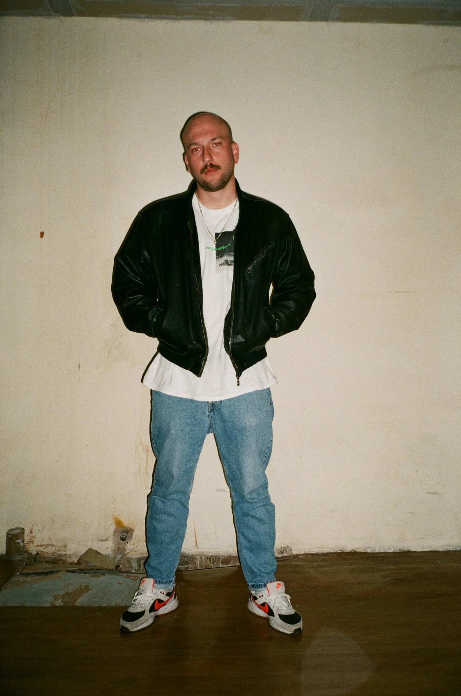 a man standing in front of a white wall and a whiteboard