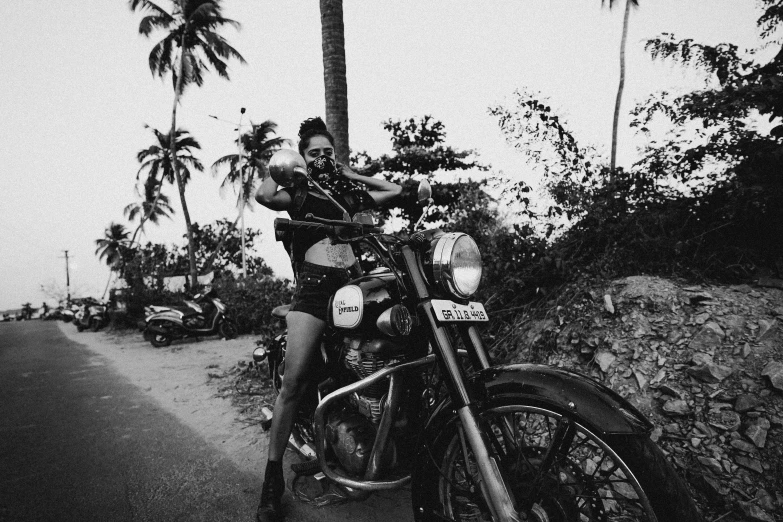 a black and white image of a woman on a motorcycle