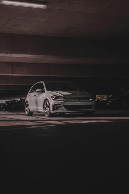 a silver sedan parked in an empty parking garage