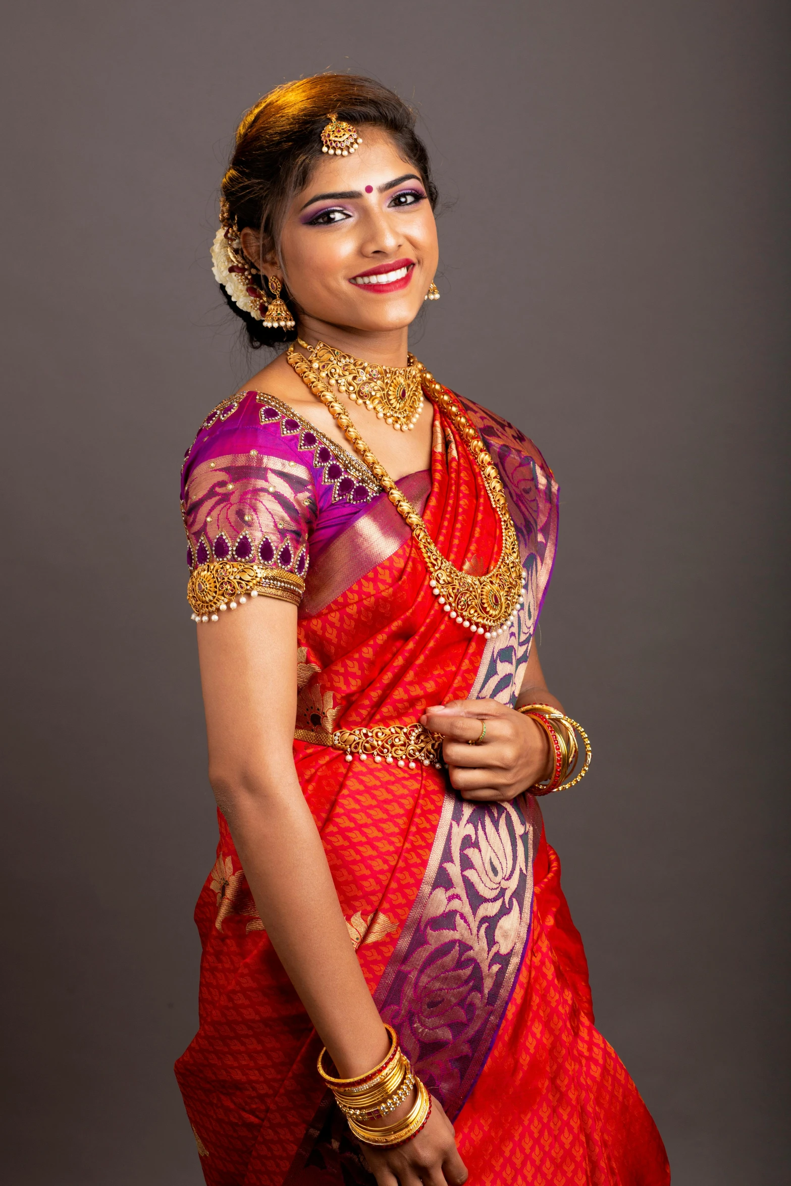 a woman in red is smiling in a traditional dress