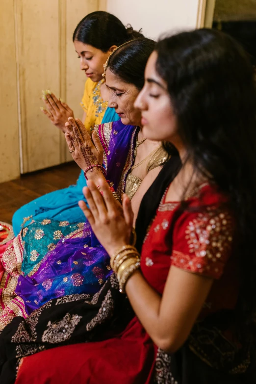 women in traditional indian garb applauding soing on the floor