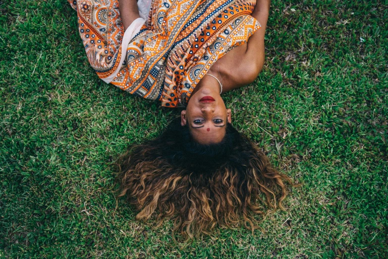 a man laying on top of a lush green field