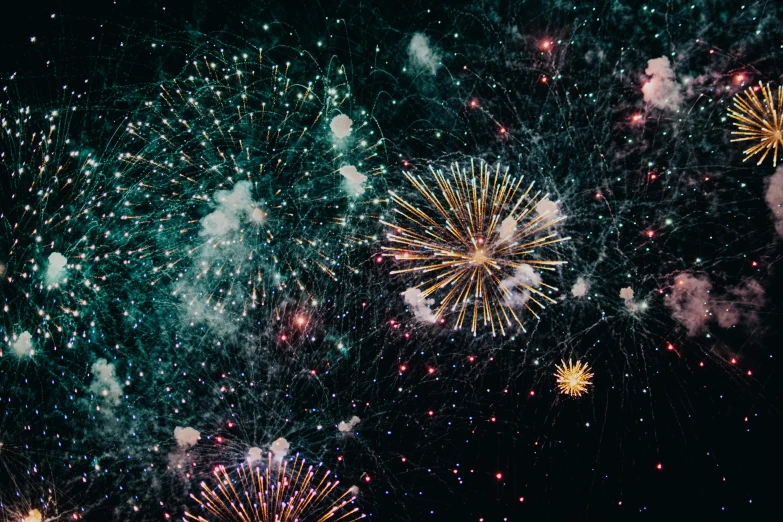 colorful fireworks displayed on a dark sky above a city