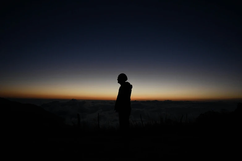 person in the distance on top of a hill at night