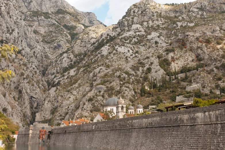 a scenic view of the town in front of mountain side