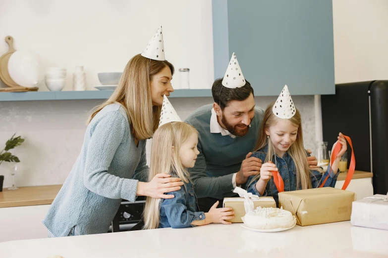 a couple and their daughters are enjoying a birthday cake
