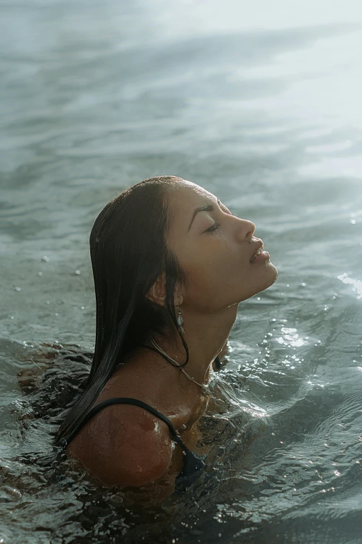 a young woman in the water breathing with her eyes closed