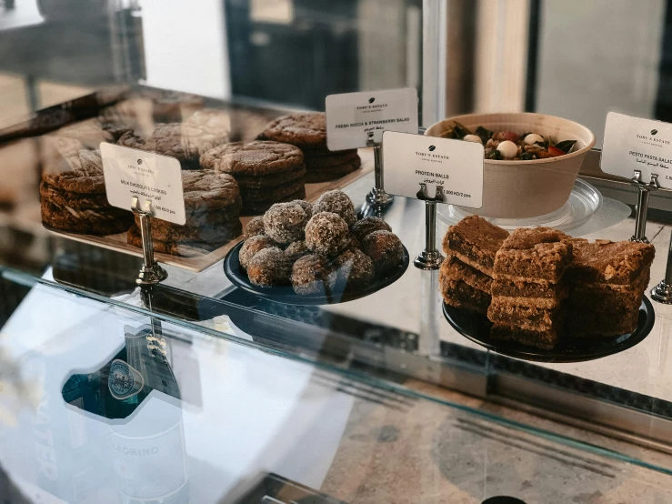 various pastries and donuts displayed behind the glass