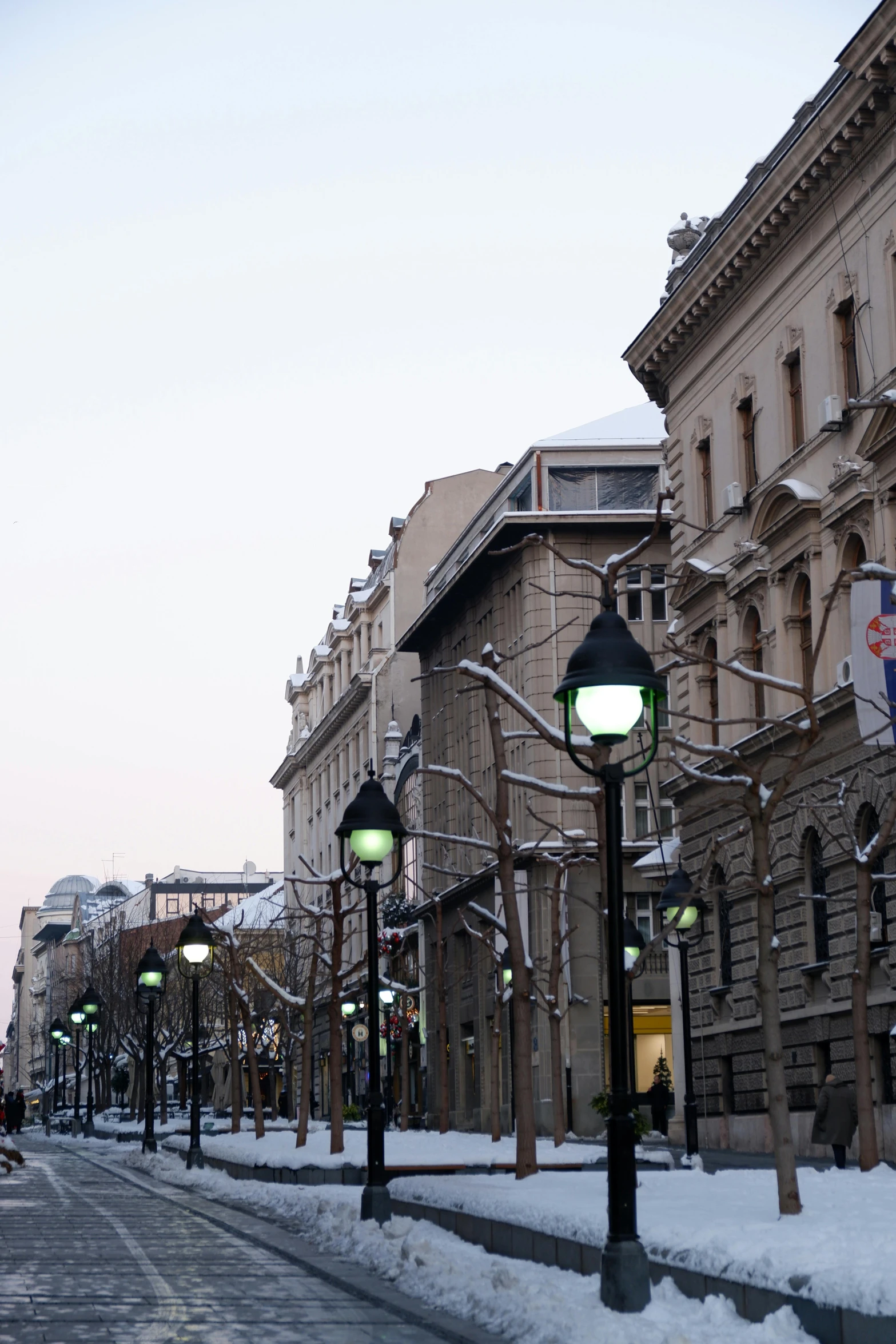 snowy streets and lamp posts in a town with historic buildings