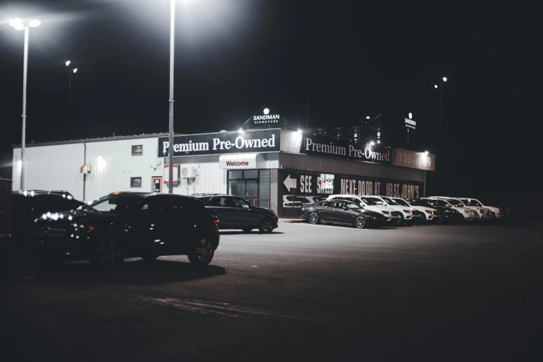 the parking lot has many parked cars and large building