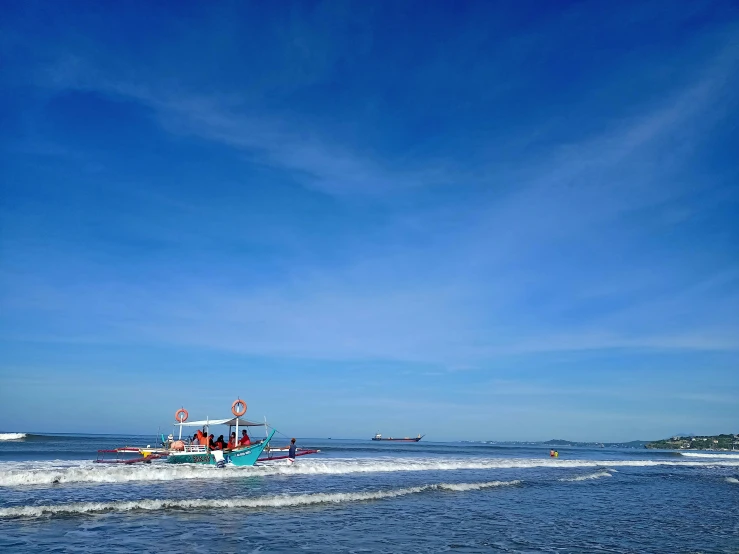 boat on the water with people standing around in the waves