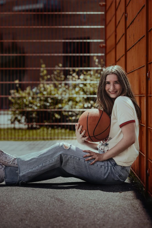 a girl is smiling while holding a basketball