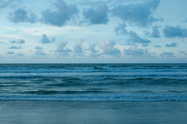 a surfer is walking along the shore holding his surfboard