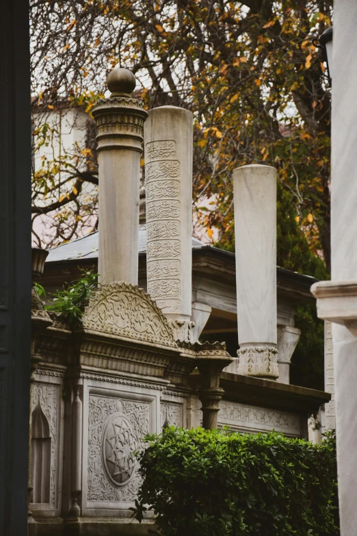 an old grave surrounded by greenery and columns