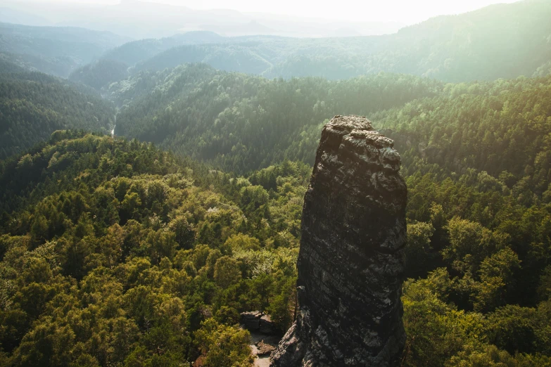 an aerial view of trees and mountains and a large rock