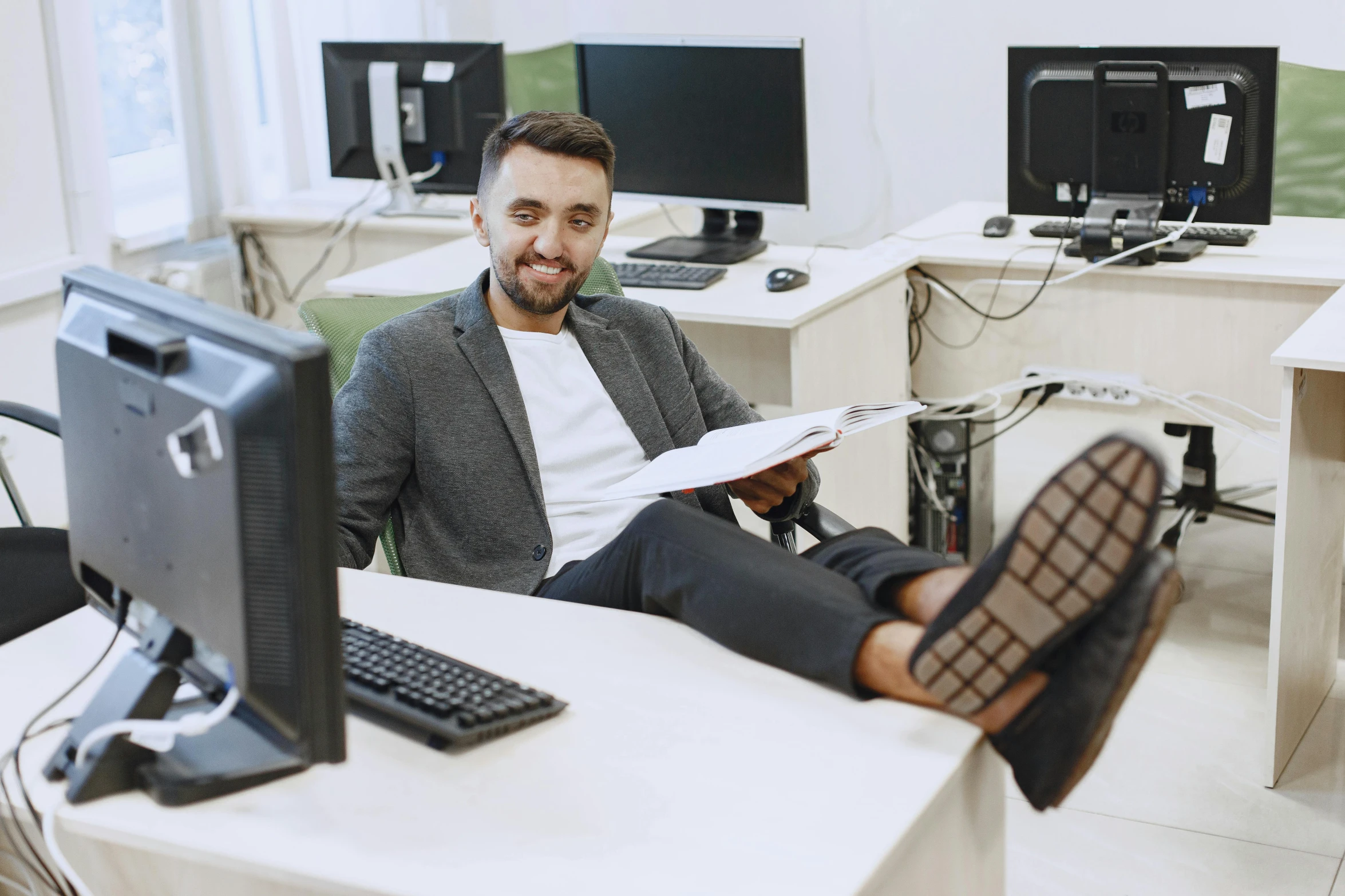 a man sitting in an office chair next to a computer and monitor