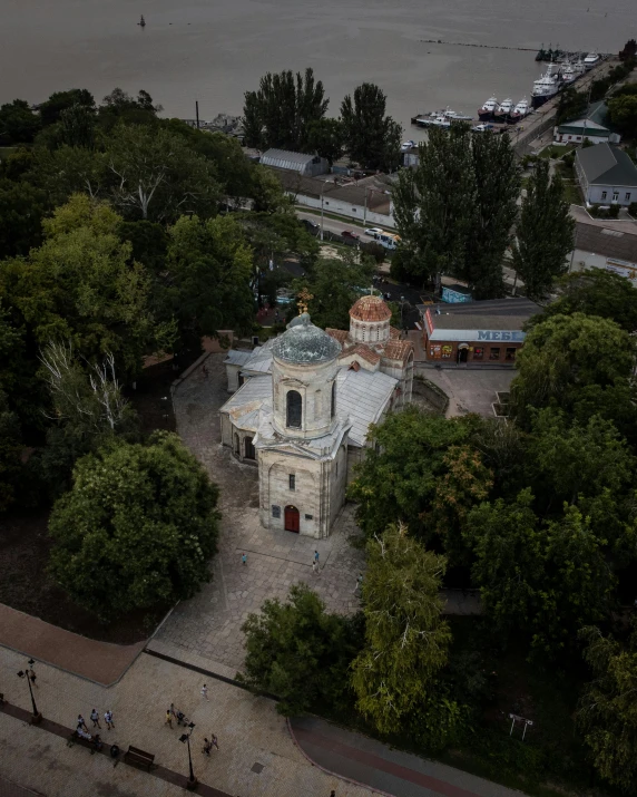 an aerial view of an old church overlooking the river