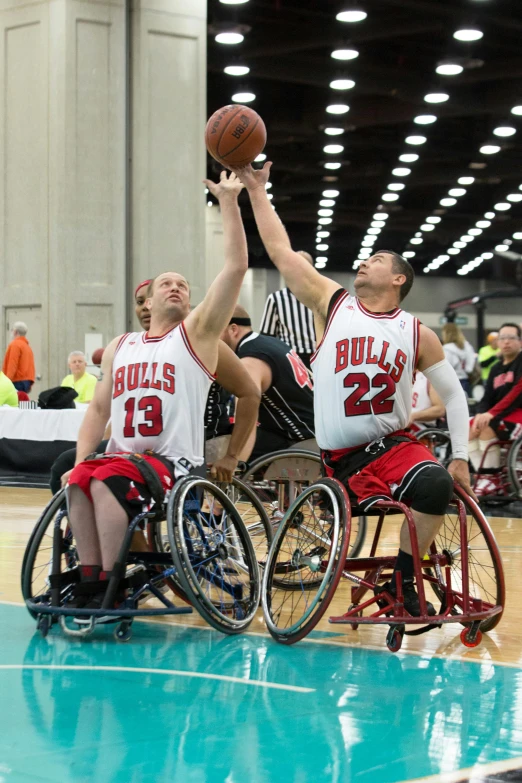 two athletes in wheelchairs are playing basketball on the court