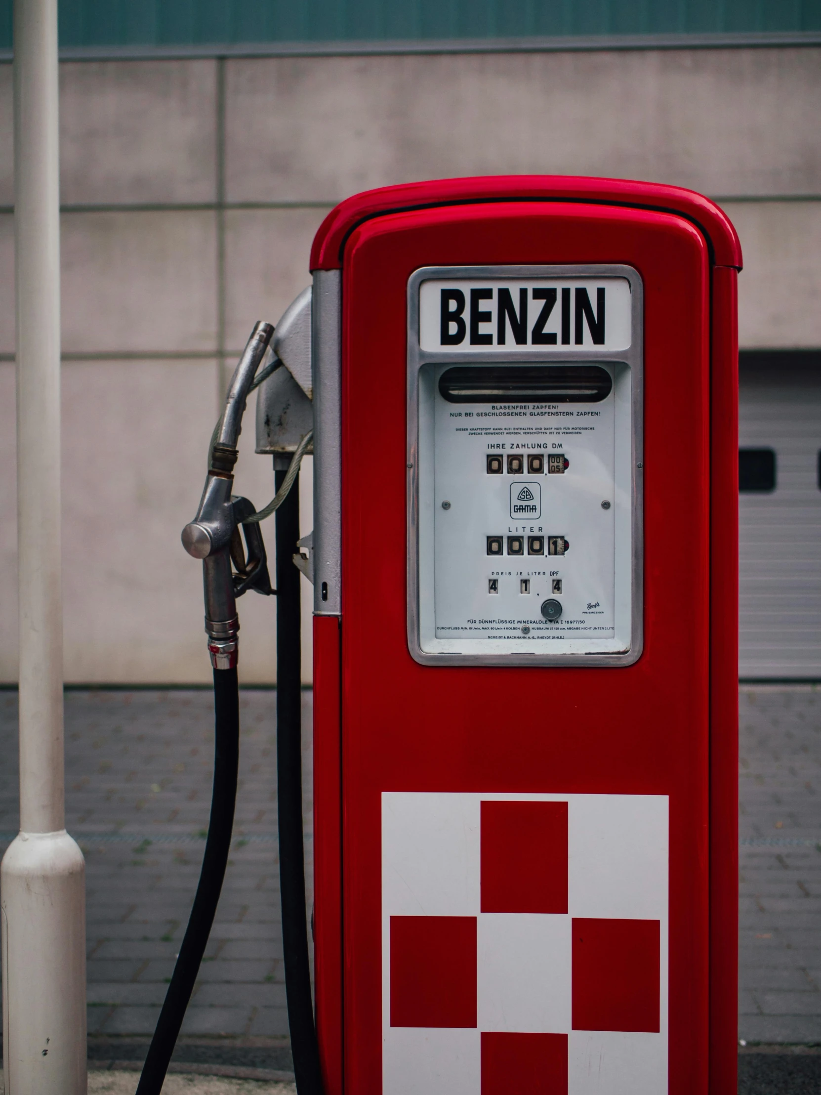 a red and white gas pump sitting next to a building