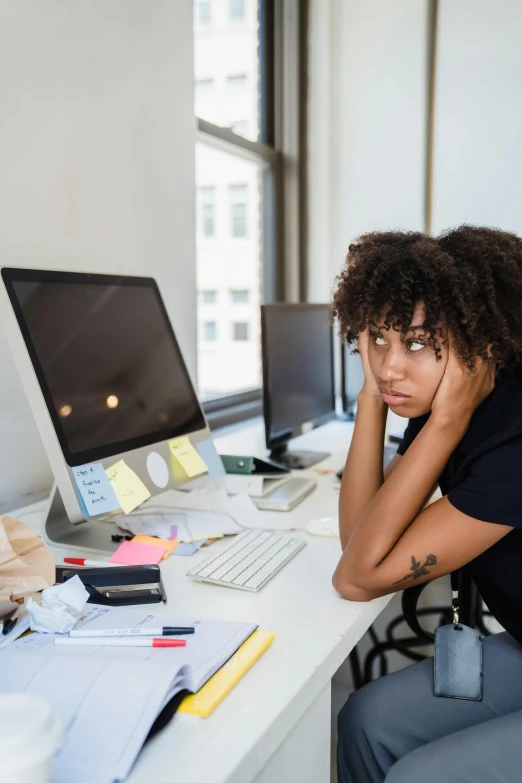 the young black woman is sitting at her desk