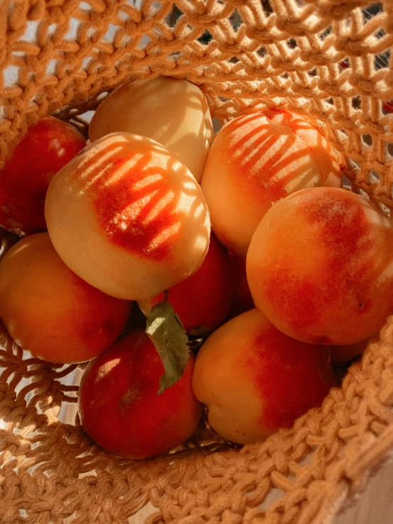 a wicker bag containing apricots on a table
