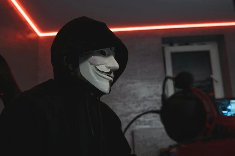 a masked man standing in front of a red light