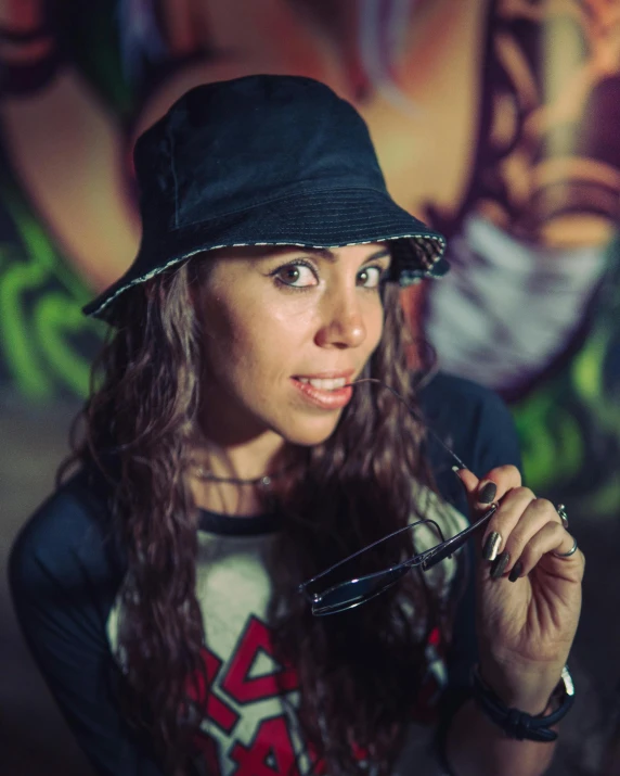 a woman with long curly hair wearing a hat and glasses