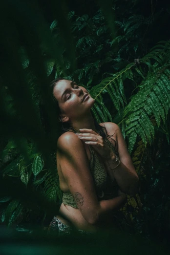 a woman is laying down in the jungle