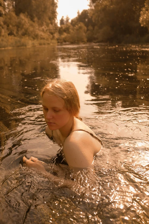 a woman is swimming in the water in a river