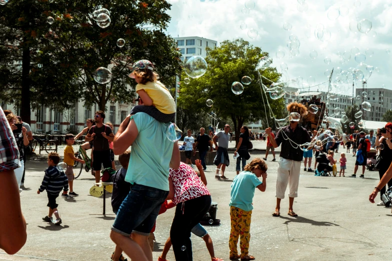 a crowd of people blowing bubbles in the air