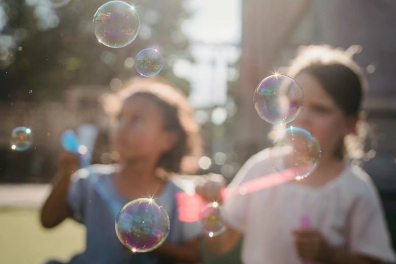 two girls standing in front of bubbles floating around