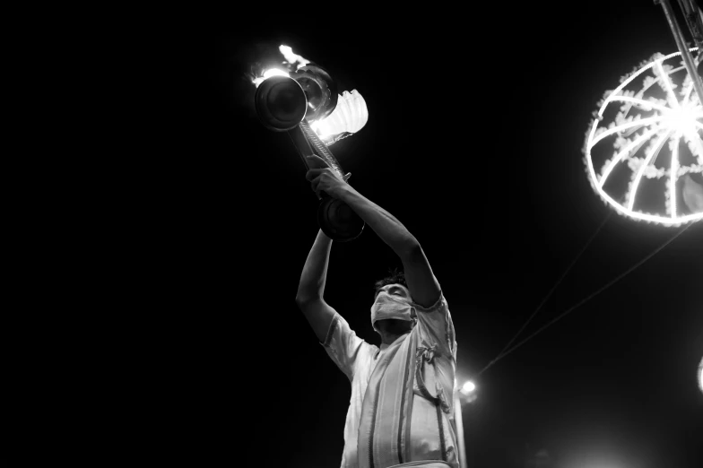 a man holding up a lantern light over his head