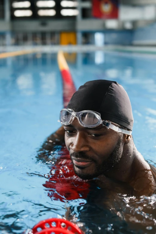 a man in goggles holding a life preserver is shown swimming