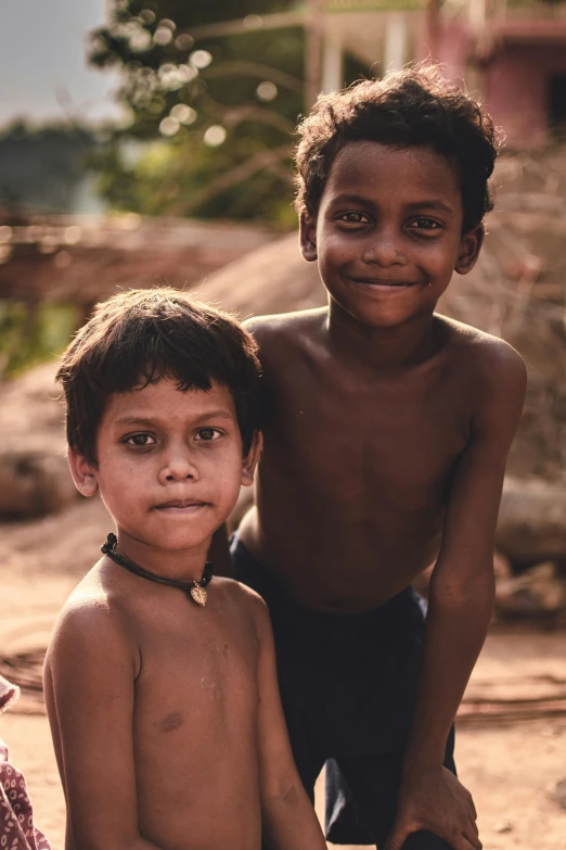 two children standing next to each other on the ground