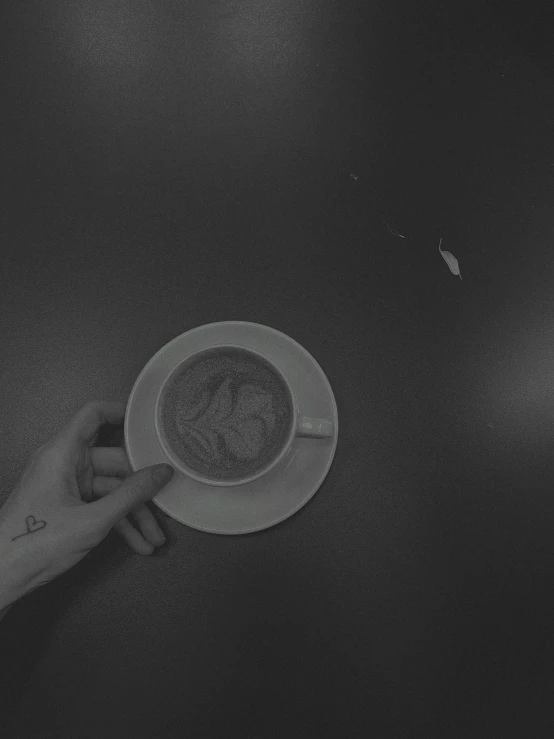 black and white image of coffee cup in a persons hand