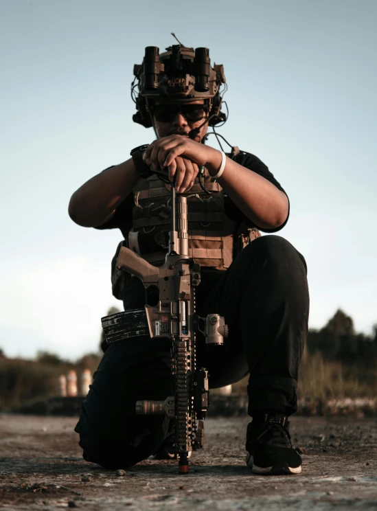 a person kneeling down with a gun in their hands