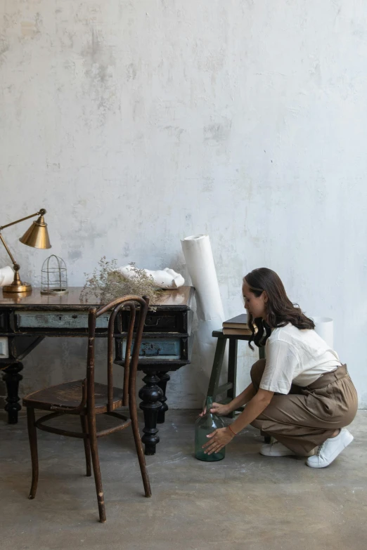 there is a woman kneeling on the floor holding a canister