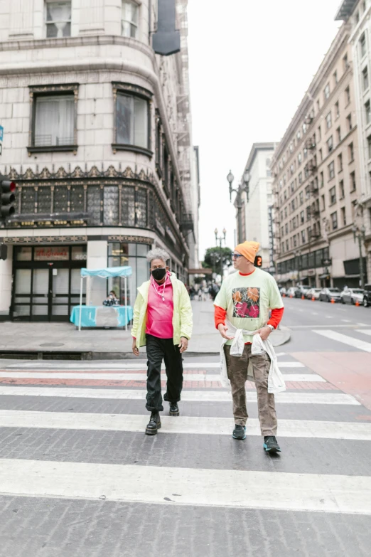 the two young men are walking across the street