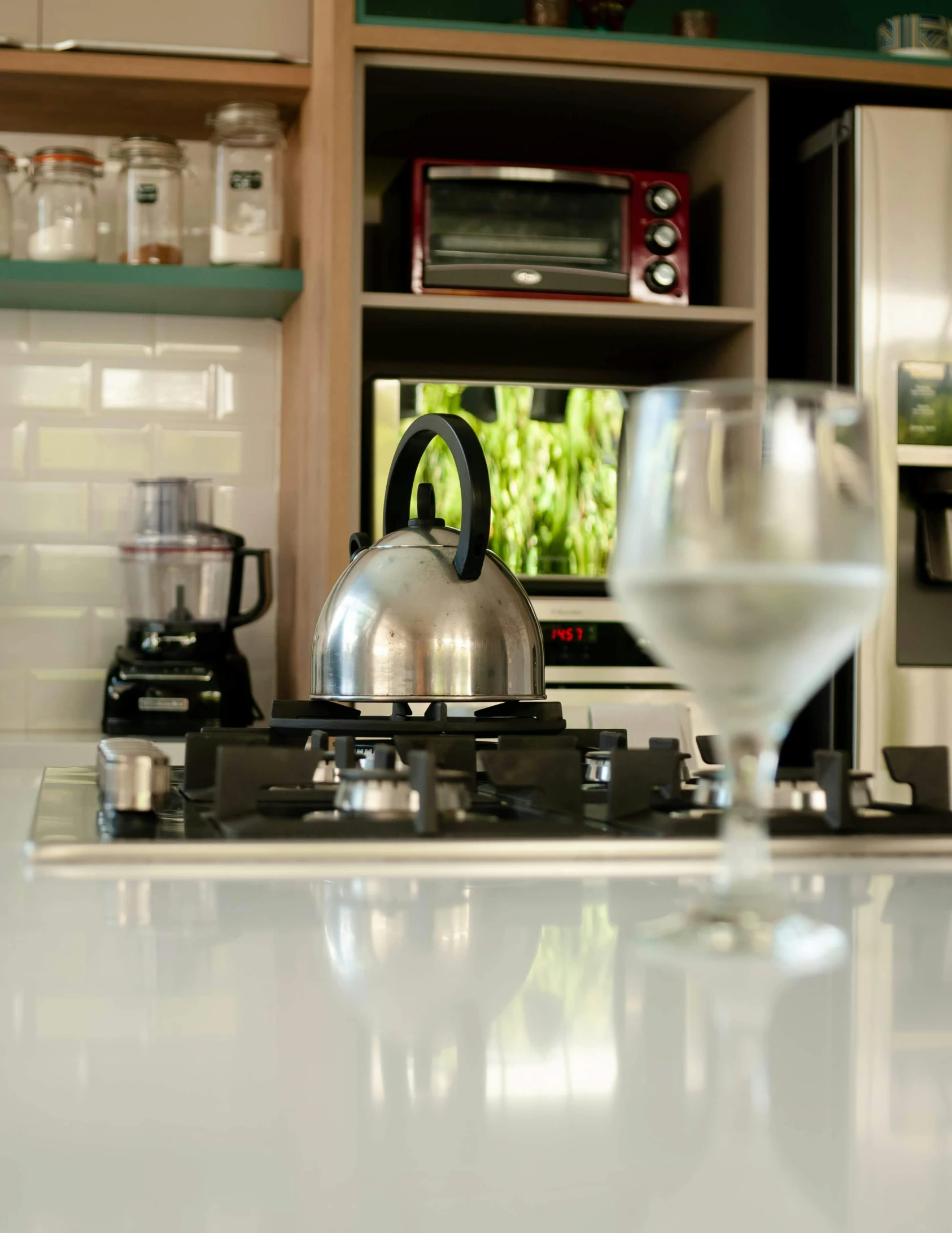 glass of wine and tea kettle on counter next to kitchen area