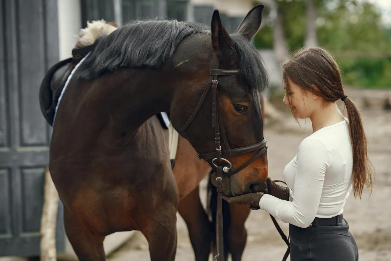 a woman is petting her horse outside