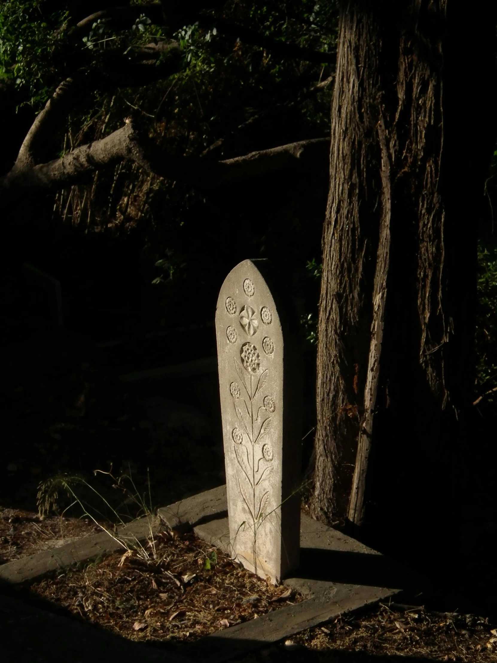 a tombstone and a tree on a grave slab