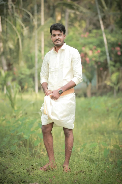 a young man in a white dress posing for the camera