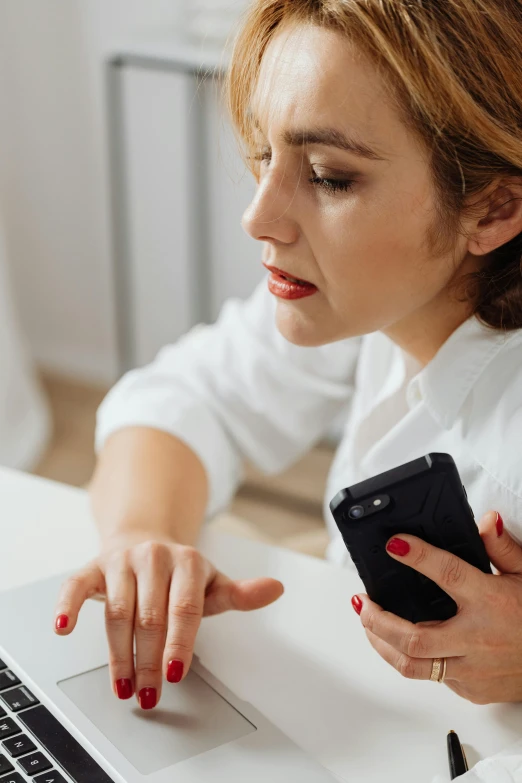 the woman is using her laptop on her desk