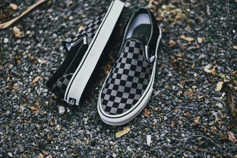 an black and white checkerboard vans on a sidewalk