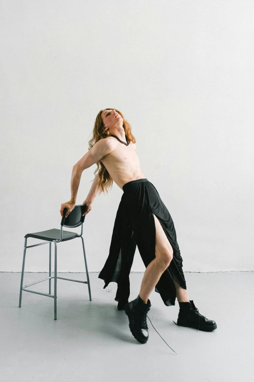 a woman in a skirt bending on a chair