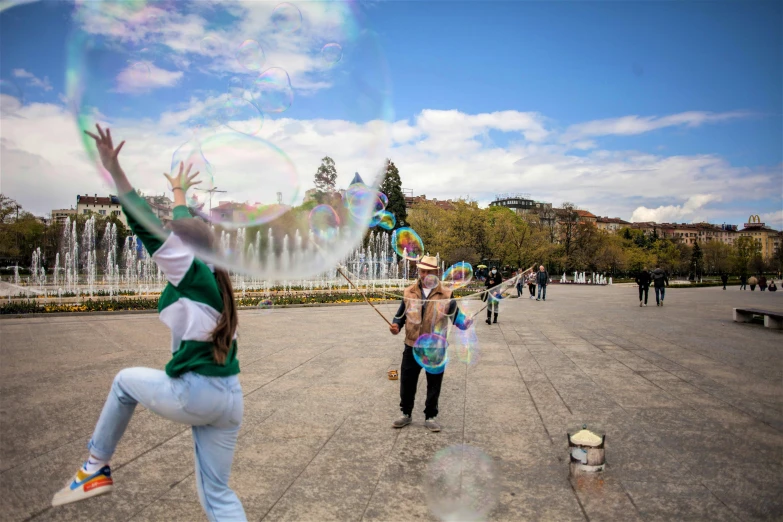 two children are playing with soap bubbles outside