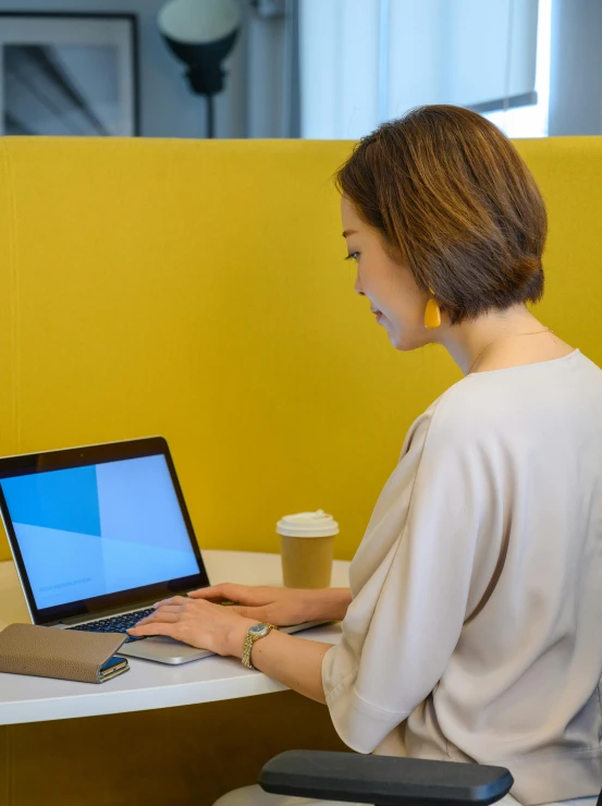 a woman is working on a laptop computer at a restaurant