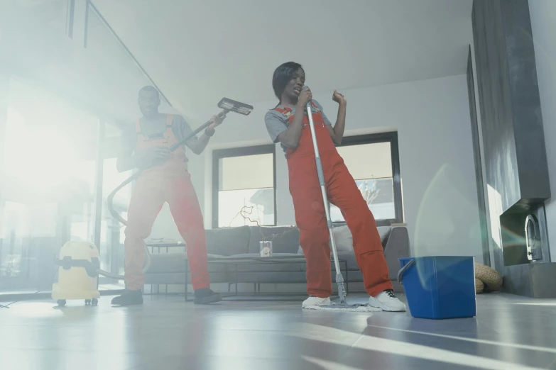 two men who are holding their phones and standing in the middle of a room